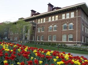 Haecker Hall with red and yellow flowers in front of it in bloom.